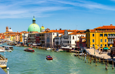 View of the canal with boats and gondolas in Venice, Italy. Venice is a popular tourist destination of Europe