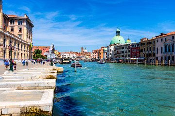 View of the canal with boats and gondolas in Venice, Italy. Venice is a popular tourist destination of Europe