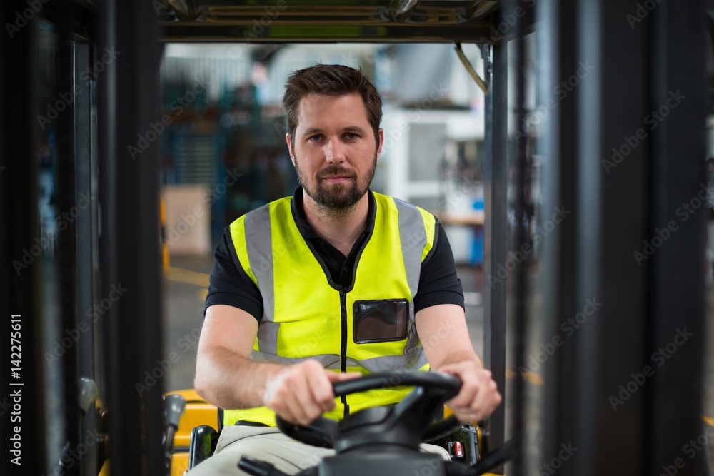 Wall mural portrait of factory worker driving forklift