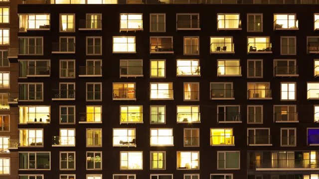Time-lapse of the exterior of a modern apartment block at night