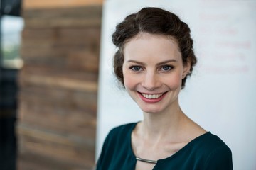 Smiling female business executive standing in office