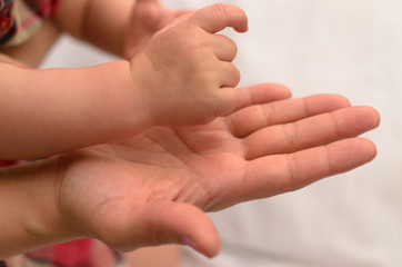 Mom's hands and arms of the child.