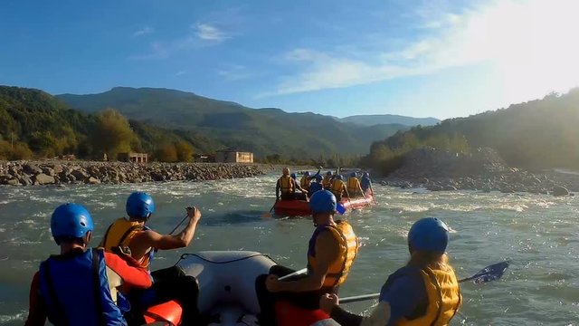 Experienced rafting teams descending river rapids on boats, extreme sports