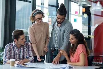 Business executives discussing over blueprint