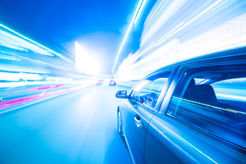 Fototapeta premium The car moves at great speed at the night. Cold color image.