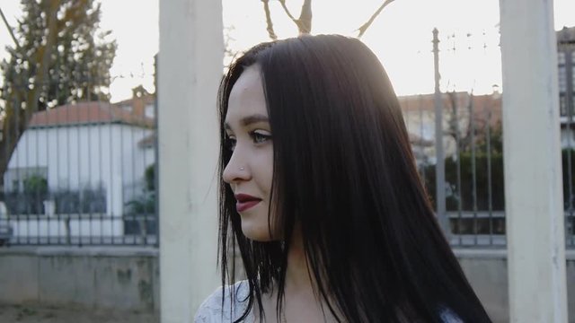 Portrait of young woman looking from right to left and flipping hair