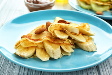 Blue plate with delicious pancakes on wooden table