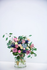 Glass vase with beautiful bouquet on light background