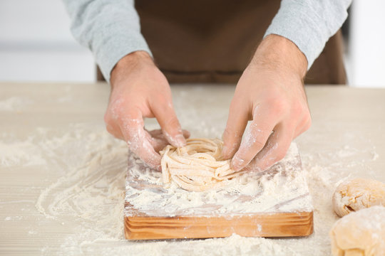 Man preparing pasta on kitchen table