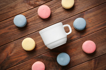 Obraz na płótnie Canvas Composition of macarons and cup on wooden background