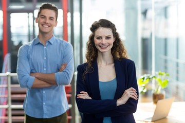 Business executives standing with arms crossed in office