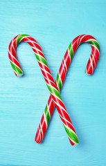 Christmas candy canes on color wooden background