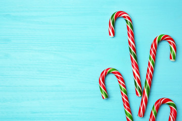 Christmas candy canes on color wooden background