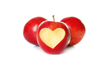 Fototapeta na wymiar Fresh red apples and one with heart-shaped cut out on white background