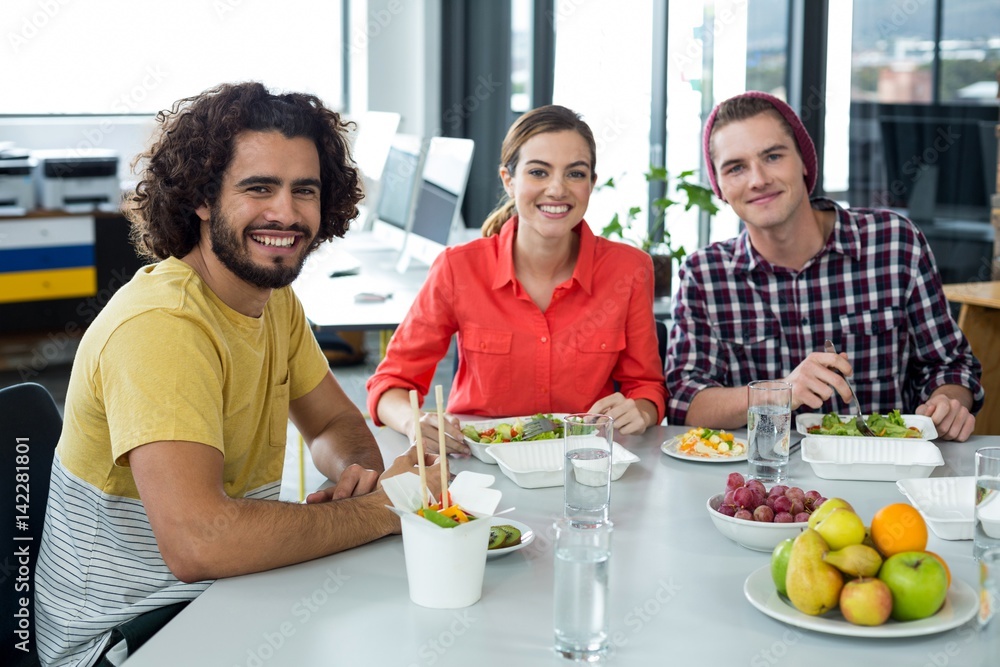 Wall mural smiling business executives having meal in office