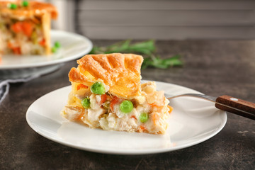 Plate with piece of delicious chicken pot pie on kitchen table