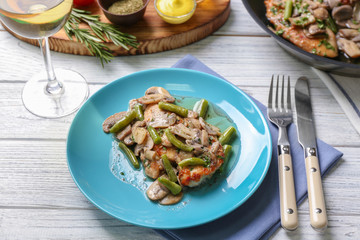Plate with delicious chicken marsala and mushrooms on table