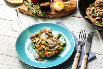 Plate with delicious chicken marsala and mushrooms on table