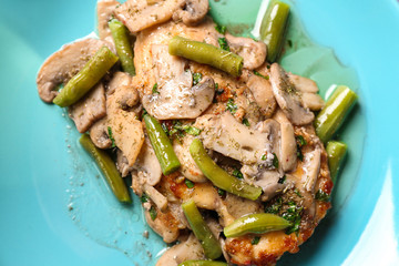 Chicken marsala with mushrooms and French beans on plate, closeup