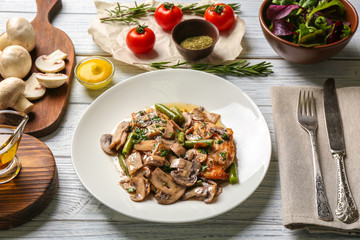 Plate with delicious chicken marsala and vegetables on table