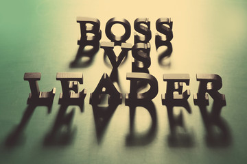 Boss vs Leader phrase made of black letters on green background