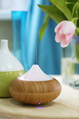 Aroma oil diffusers and flowers on table