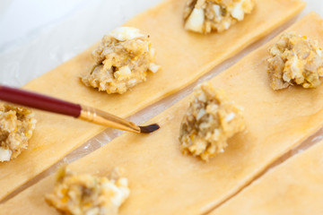 Ravioli Preparation :  Painting ravioli dough with water to seal it