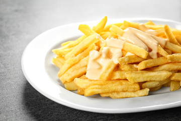 Delicious french fries with cheese sauce, closeup