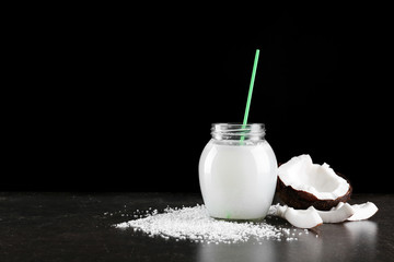 Composition with fresh coconut milk on table against dark background