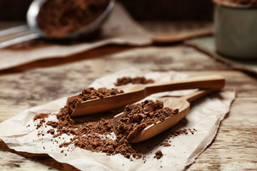 Wooden spoons with cocoa powder on paper napkin