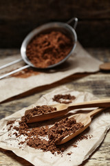 Wooden spoons with cocoa powder on paper napkin