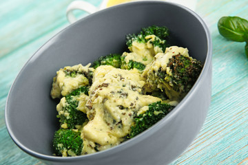 Grey bowl of delicious broccoli with cheese cream, closeup