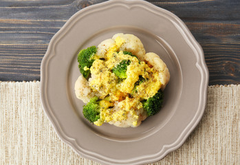 Delicious cauliflower and broccoli with cheese sauce on grey plate