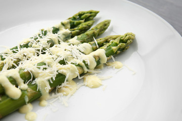 White plate of delicious asparagus with cheese cream, closeup