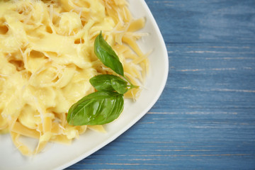 Portion of delicious pasta with cheese sauce on plate, closeup