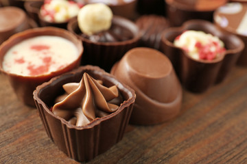 Delicious chocolate candies on wooden background