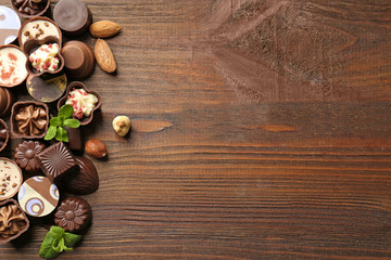 Delicious chocolate candies on wooden background