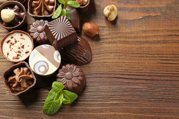 Delicious chocolate candies on wooden background