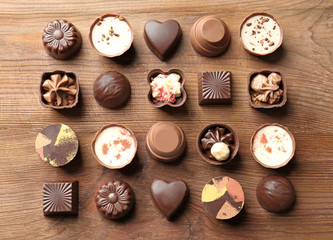 Delicious chocolate candies on wooden background
