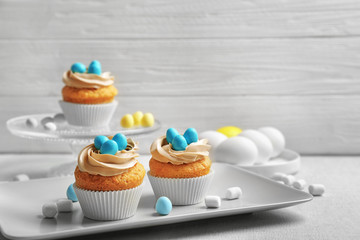 Easter cupcakes on table against grey wooden background