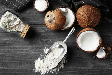 Coconut flour in metal scoop on wooden table