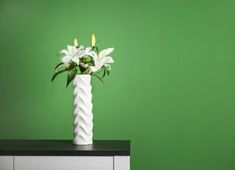 Beautiful white lilies in vase on table