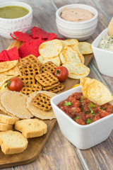 Variety of snacks with dips and salsa.