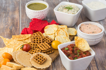 Variety of snacks with dips and salsa.
