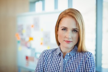Portrait of female executive standing in conference room
