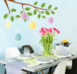 Table served with dishes and a bouquet of tulips