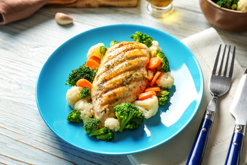 Tasty chicken breast and vegetables on plate