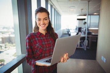 Obraz na płótnie Canvas Female business executive holding laptop