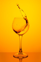 Splash of water in a glass on yellow