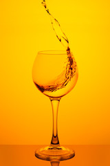 Splash of water in a glass on yellow
